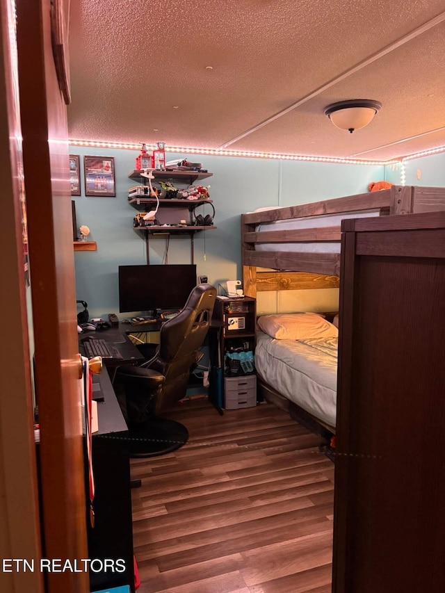 bedroom with a textured ceiling and hardwood / wood-style flooring