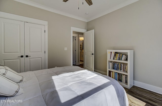 bedroom with wood finished floors, a ceiling fan, baseboards, a closet, and crown molding