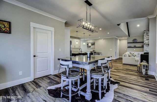 dining space with ornamental molding, dark wood finished floors, and baseboards