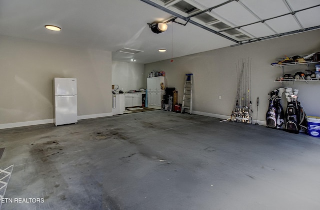 garage with baseboards and freestanding refrigerator