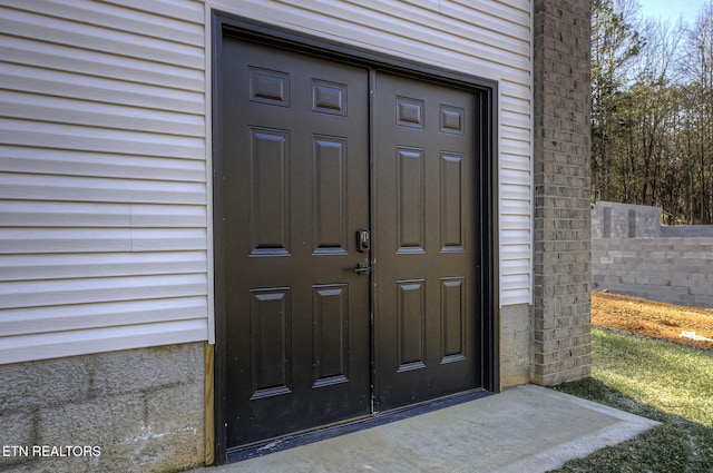 view of exterior entry featuring fence