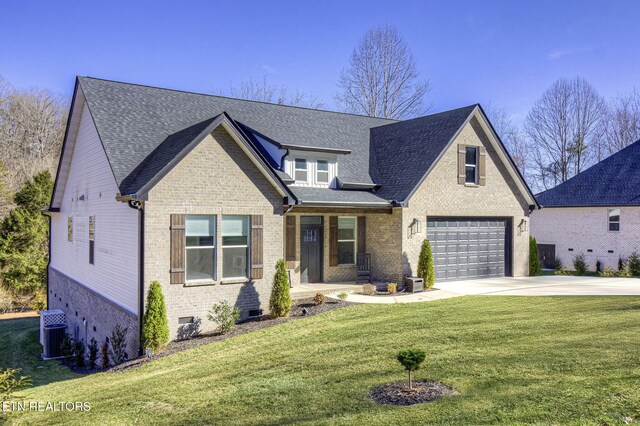 view of front of home with driveway, a garage, central AC unit, a front lawn, and brick siding