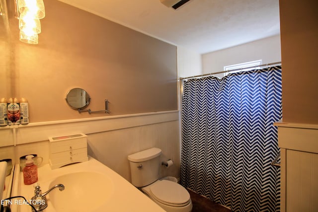 bathroom with sink, curtained shower, and toilet