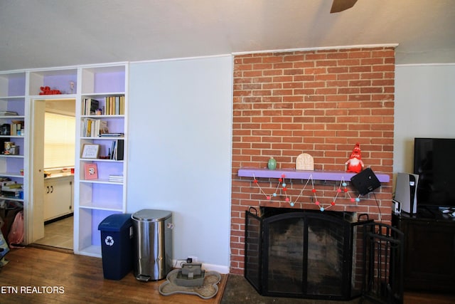 living room featuring a brick fireplace and hardwood / wood-style floors