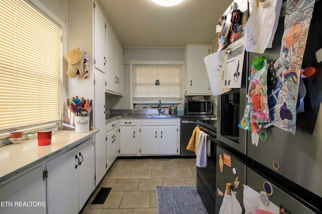 kitchen featuring white cabinetry, appliances with stainless steel finishes, sink, and light tile patterned floors