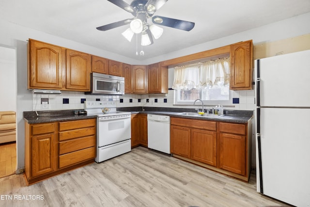 kitchen with sink, light wood-type flooring, decorative backsplash, ceiling fan, and white appliances