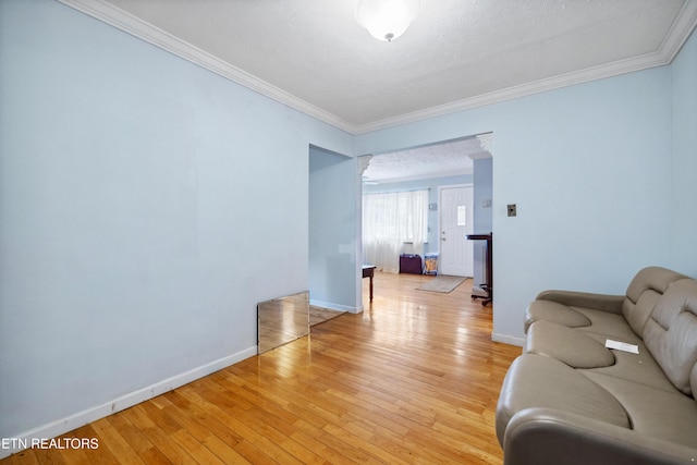 living room with ornamental molding and light hardwood / wood-style flooring