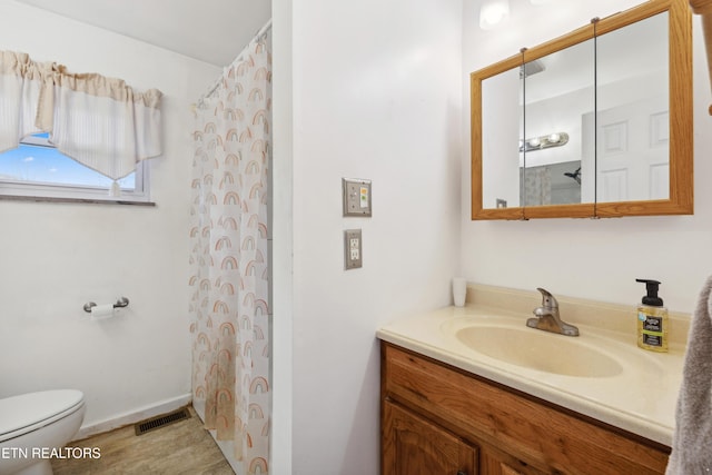 bathroom featuring vanity, curtained shower, and toilet