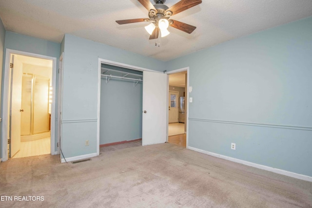 unfurnished bedroom with light colored carpet, a textured ceiling, stainless steel fridge, a closet, and ceiling fan