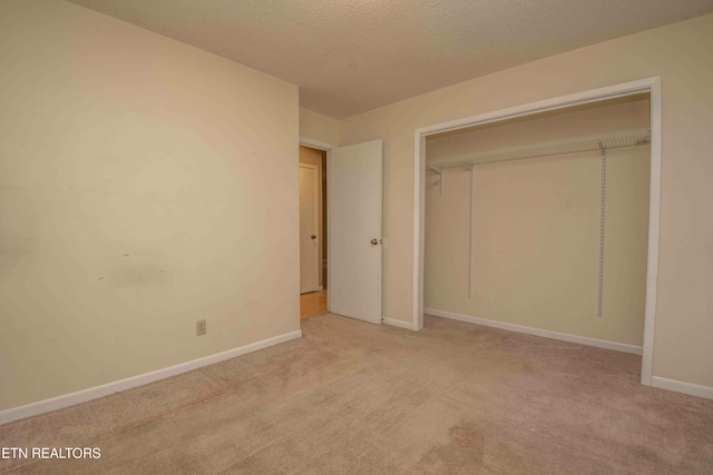 unfurnished bedroom featuring light carpet and a textured ceiling