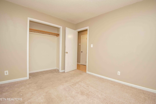 unfurnished bedroom featuring light carpet and a closet