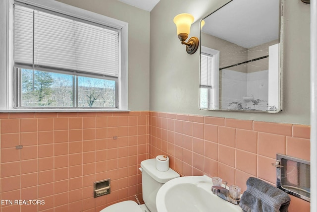 bathroom with tile walls and toilet