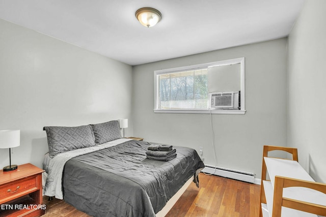 bedroom featuring hardwood / wood-style flooring and baseboard heating