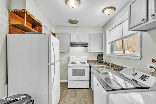 kitchen featuring white appliances, light hardwood / wood-style flooring, washing machine and clothes dryer, sink, and gray cabinetry