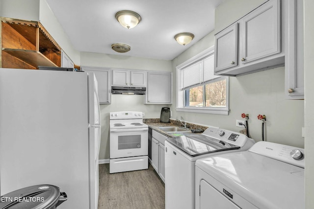 washroom with separate washer and dryer, light hardwood / wood-style flooring, and sink