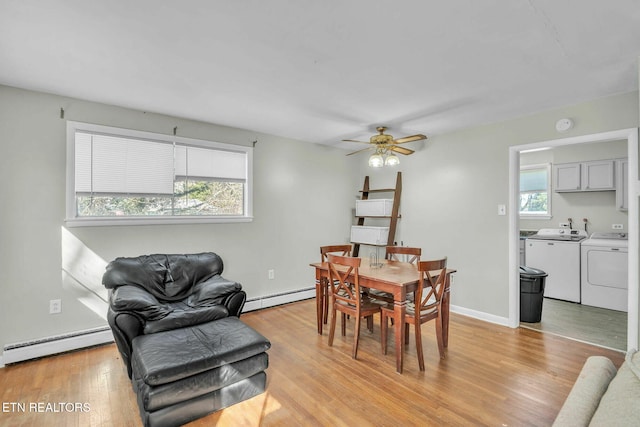 dining room featuring a wealth of natural light, baseboard heating, and washer and dryer