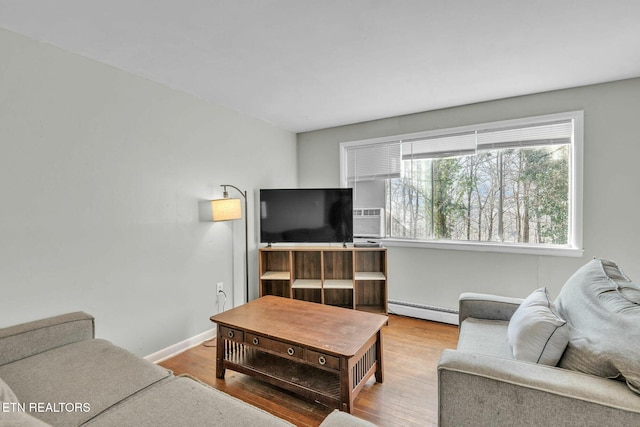 living room with a baseboard heating unit and hardwood / wood-style floors