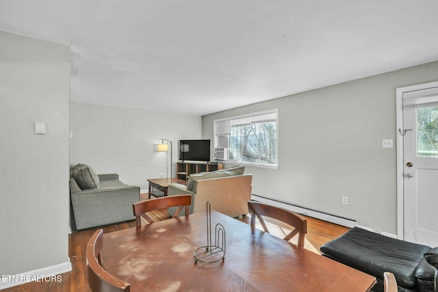 dining room with a baseboard radiator, hardwood / wood-style floors, and a healthy amount of sunlight