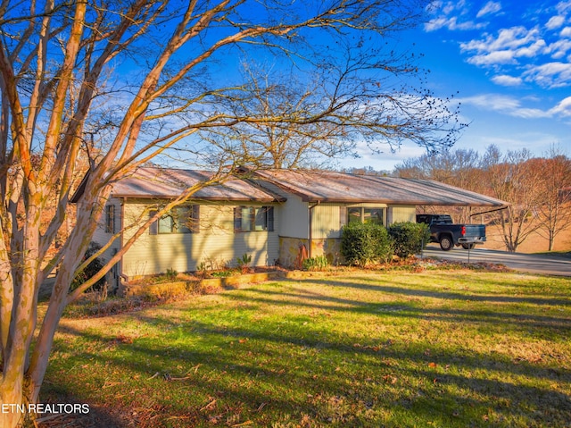 single story home with a front yard and a carport