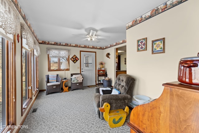 sitting room with ceiling fan and carpet flooring