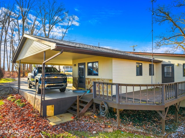 rear view of house with a carport and a wooden deck