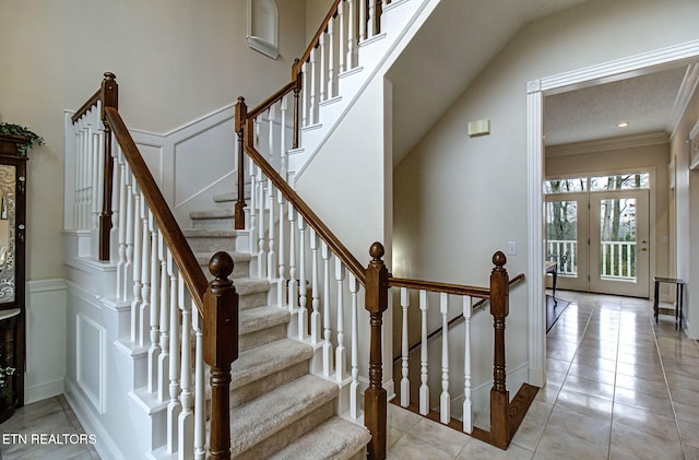 stairs with french doors, ornamental molding, and tile patterned flooring