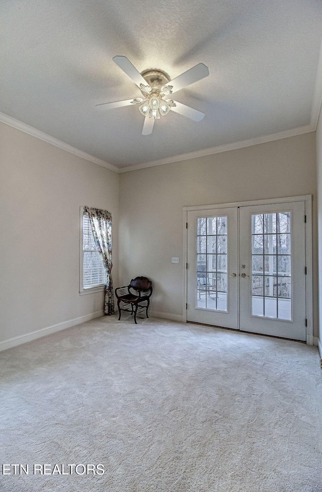 interior space featuring crown molding, ceiling fan, a textured ceiling, light carpet, and french doors