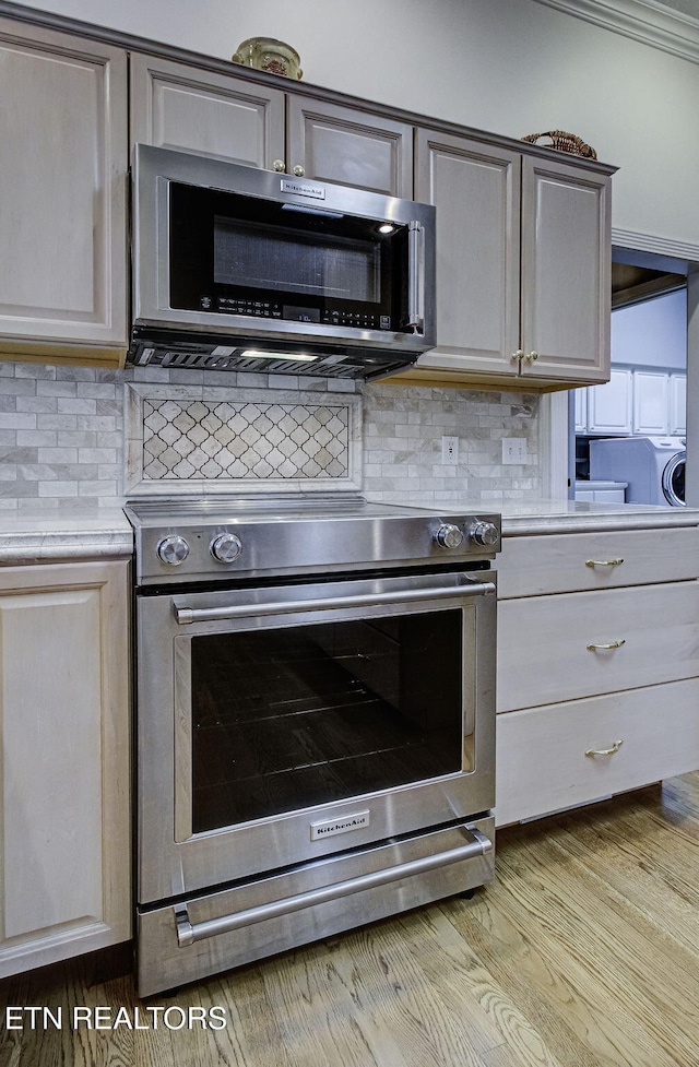 kitchen featuring tasteful backsplash, appliances with stainless steel finishes, and light hardwood / wood-style flooring