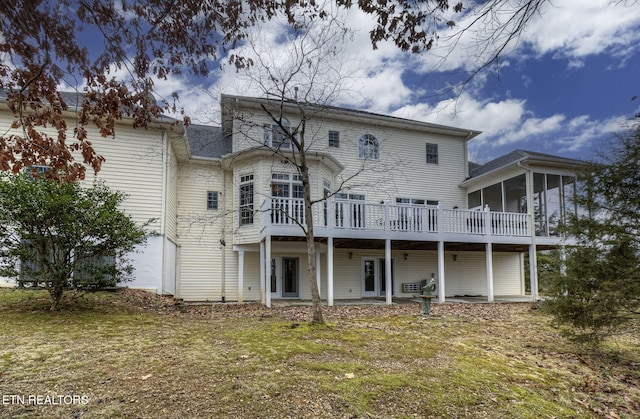 rear view of property featuring a yard and a deck