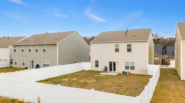 back of property with a lawn and a patio