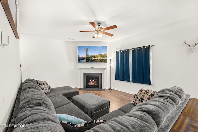 living room with ceiling fan, wood-type flooring, and beamed ceiling