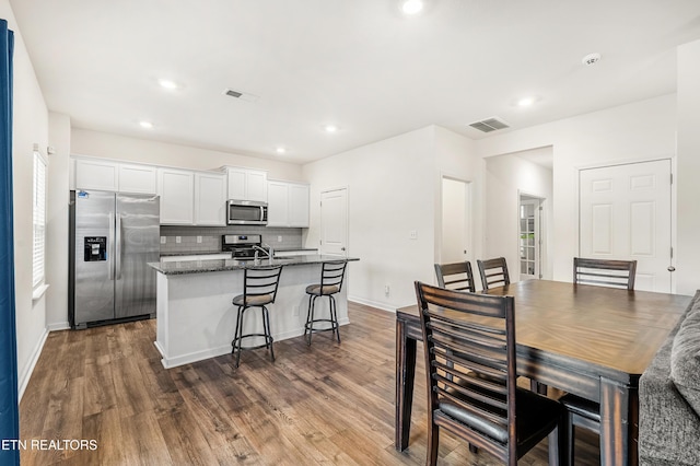 dining space featuring sink and dark wood-type flooring