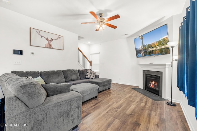 living room featuring wood-type flooring and ceiling fan