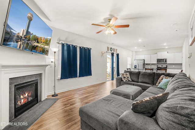 living room featuring light hardwood / wood-style flooring and ceiling fan