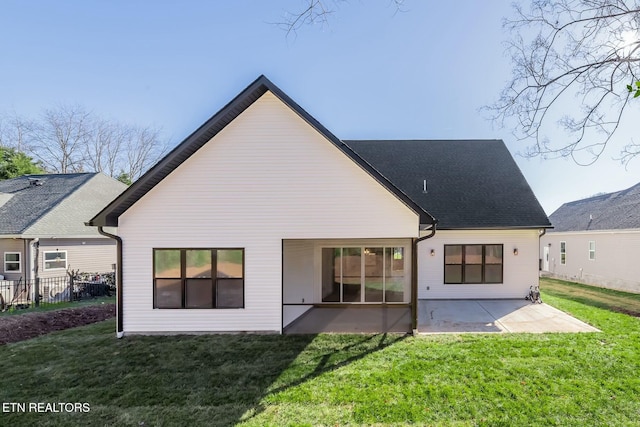 back of property with a lawn and a patio