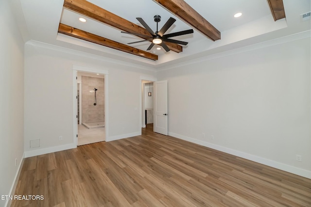 empty room with ceiling fan, a raised ceiling, and light hardwood / wood-style flooring