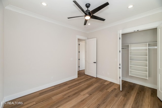 unfurnished bedroom featuring a closet, ceiling fan, hardwood / wood-style floors, and crown molding