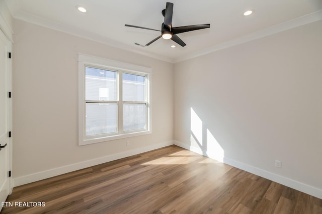 empty room with ceiling fan, ornamental molding, and wood-type flooring