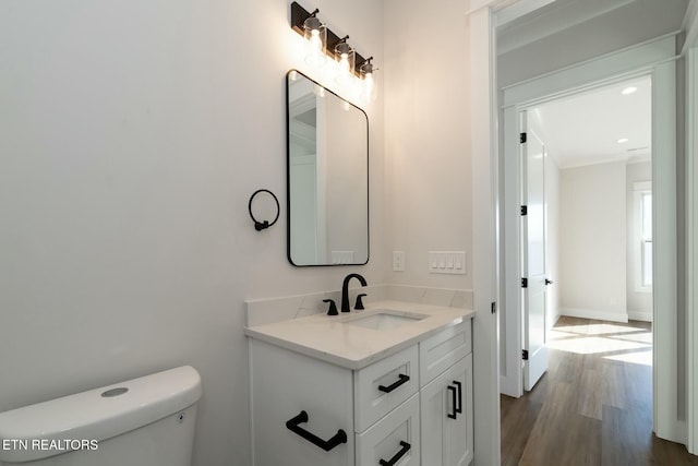 bathroom featuring vanity, toilet, and hardwood / wood-style floors