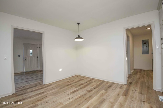 unfurnished dining area featuring light hardwood / wood-style floors and electric panel