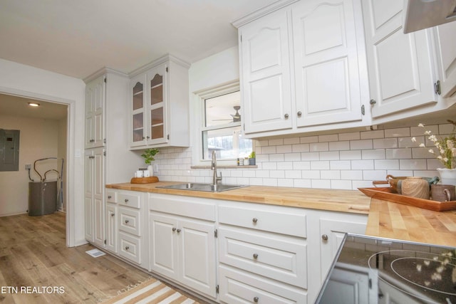 kitchen featuring butcher block counters, sink, and white cabinets