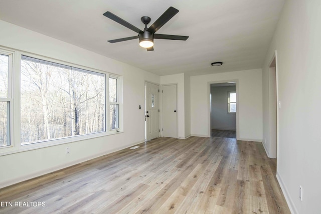 empty room with ceiling fan and light wood-type flooring