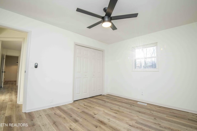 unfurnished bedroom featuring a closet, ceiling fan, and light wood-type flooring