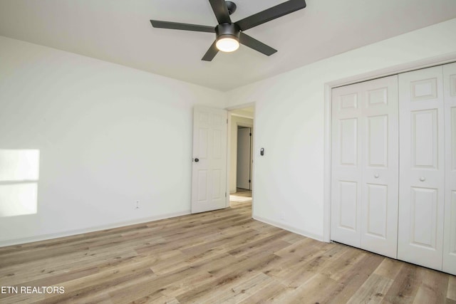 unfurnished bedroom featuring light hardwood / wood-style flooring, a closet, and ceiling fan