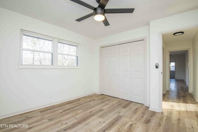 unfurnished bedroom with multiple windows, a closet, ceiling fan, and light wood-type flooring