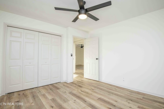 unfurnished bedroom featuring ceiling fan, light hardwood / wood-style floors, and a closet