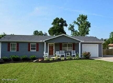 single story home with a front yard, a porch, and a garage