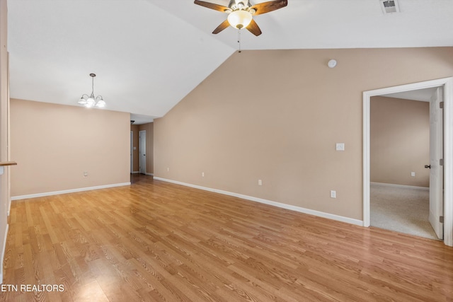 unfurnished living room with ceiling fan with notable chandelier, light hardwood / wood-style flooring, and lofted ceiling