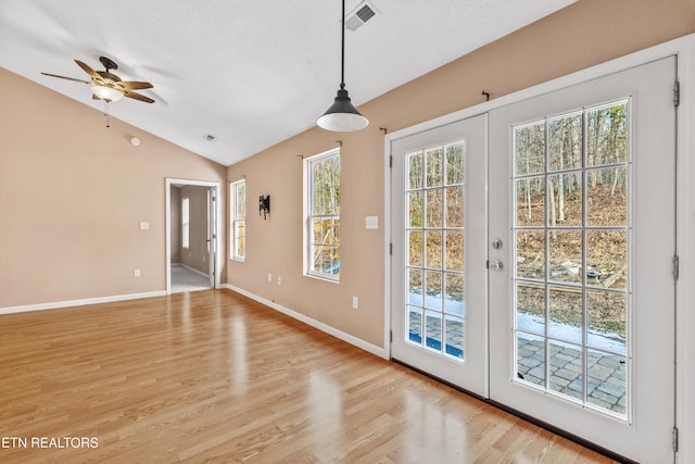 doorway with light hardwood / wood-style floors, ceiling fan, french doors, and vaulted ceiling