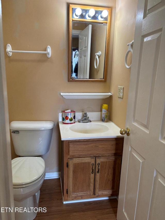 bathroom with vanity, hardwood / wood-style floors, and toilet